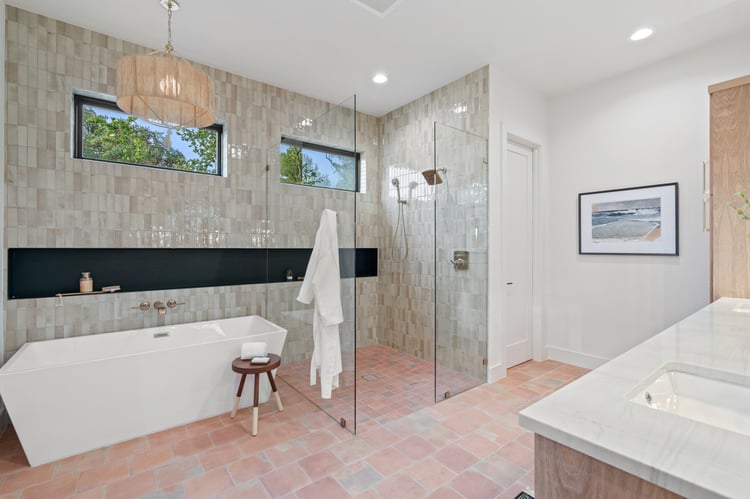 Freestanding tub and glass shower in a tiled bathroom of a custom home in Austin, TX by J. Angelo Design Build