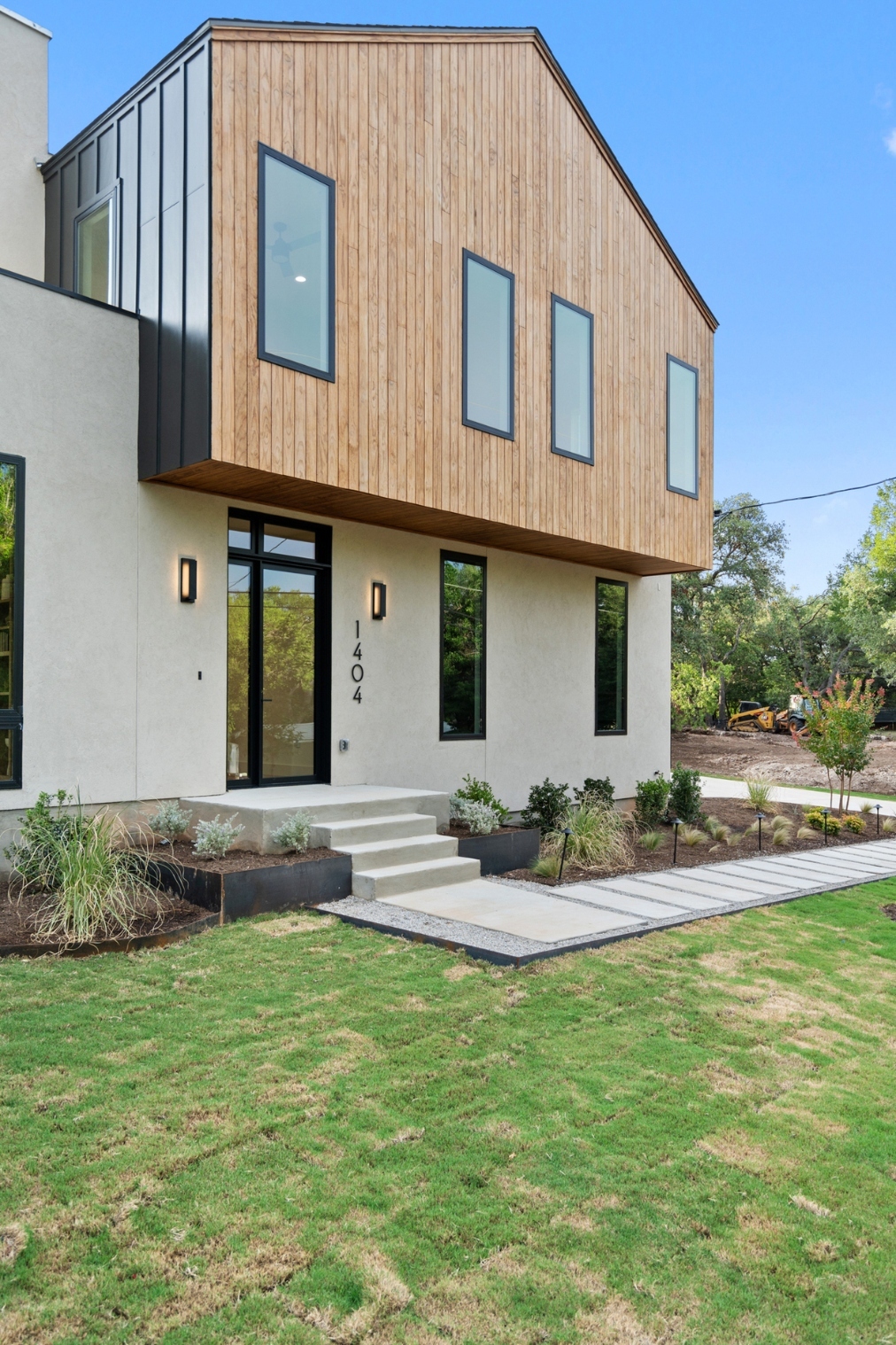 Front angle of modern custom home with natural wood siding in Austin, TX by J. Angelo Design Build