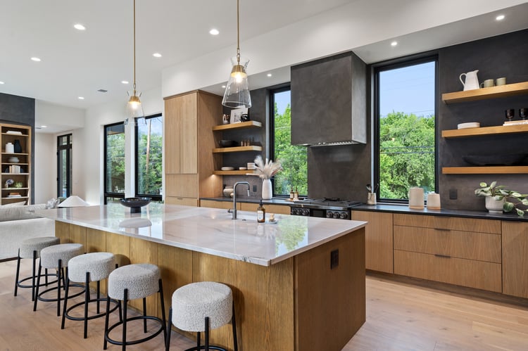 Open kitchen layout with quartz island and wood accents in a custom home in Austin, TX by J. Angelo Design Build Open kitchen layout with quartz island and wood accents in a custom home in Austin, TX by J. Angelo Design Build