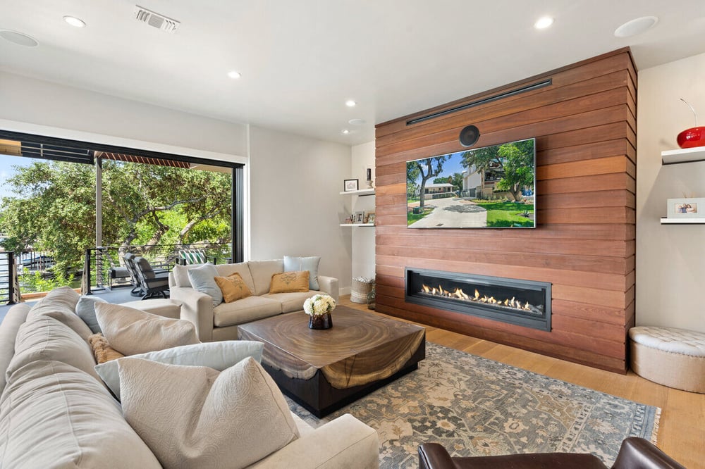 Luxurious lakefront living space with warm wood accents and an open-concept design in a custom home on Lake LBJ by J. Angelo Design Build in Austin, TX