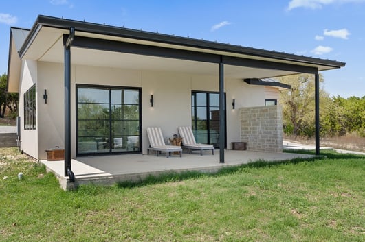 Angled exterior view of a detached casita by J. Angelo Design Build in Austin, TX with a covered patio and lounge seating