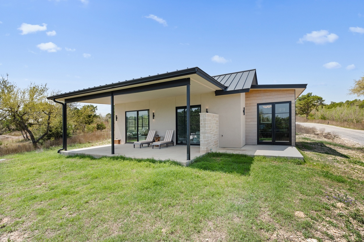 Rear patio view of a detached casita by J. Angelo Design Build in Austin, TX with a shaded lounge area