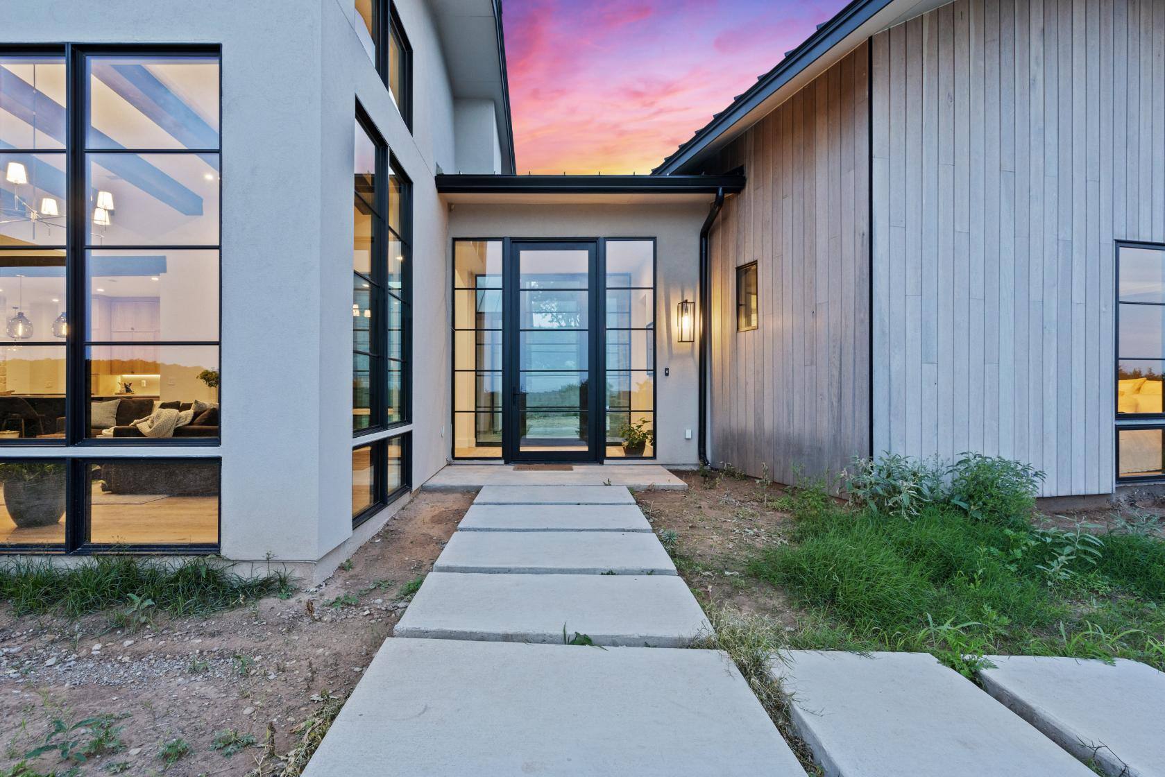 Front entrance of custom home with large windows and stone pathway by J. Angelo Design Build