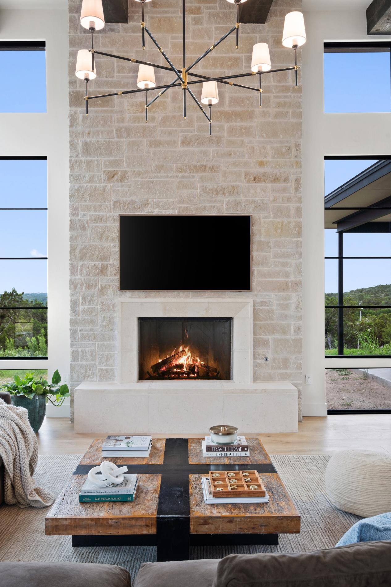 Stone fireplace featured in living room with lots of natural light