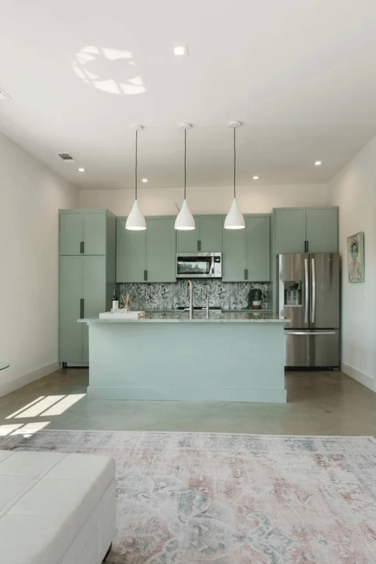 Open-concept kitchen and living space with sage green cabinets in a detached casita by J. Angelo Design Build (1)