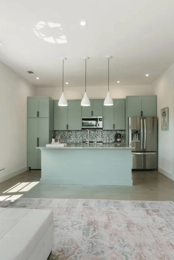 Open-concept kitchen and living space with sage green cabinets in a detached casita by J. Angelo Design Build (1)