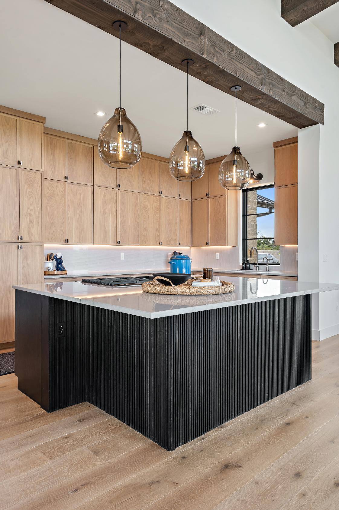 Modern kitchen with plenty of cabinet space, island, gas stove, and sink by J. Angelo Design Build