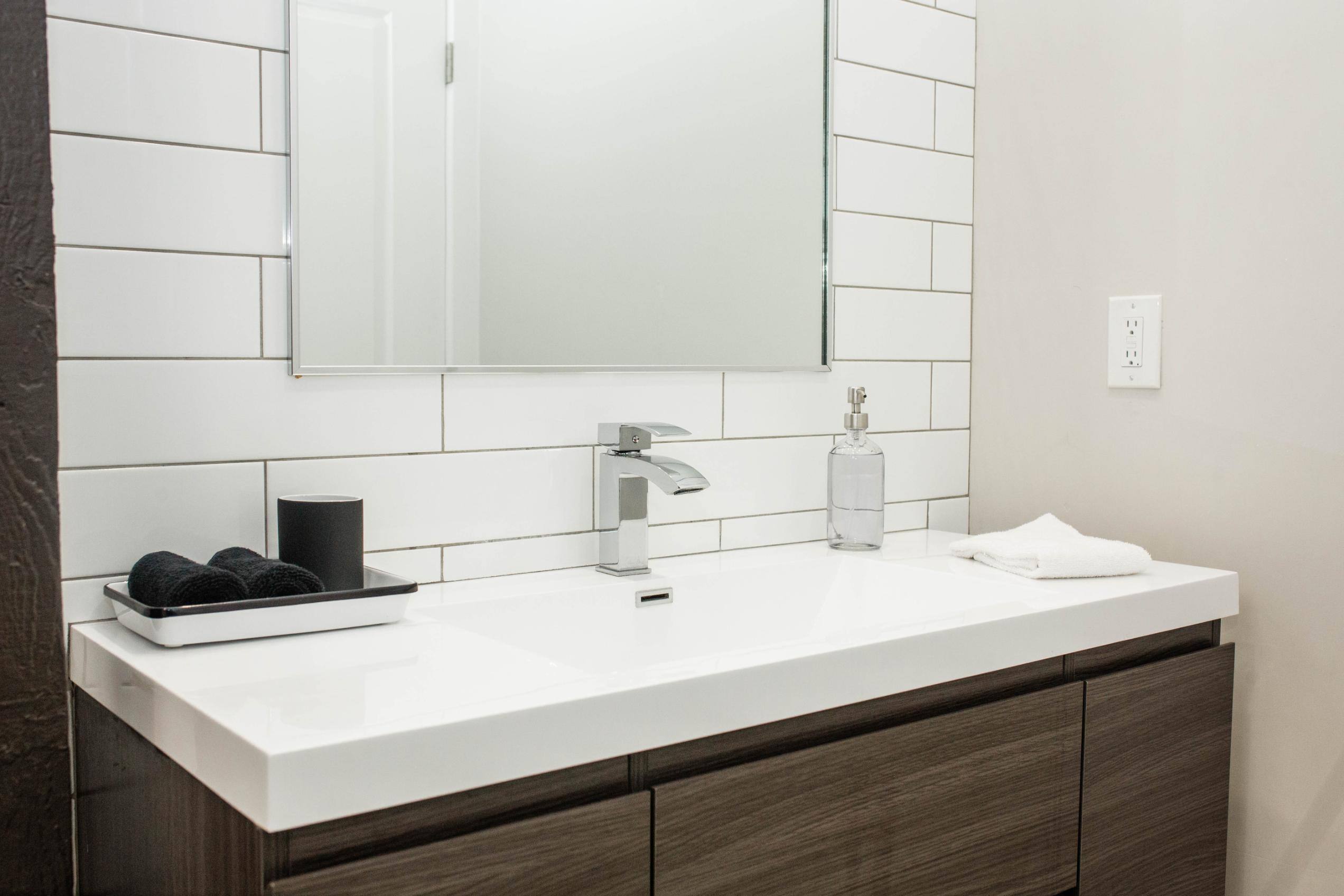 Remodeled bathroom with white tile backsplash by J. Angelo Design + Build