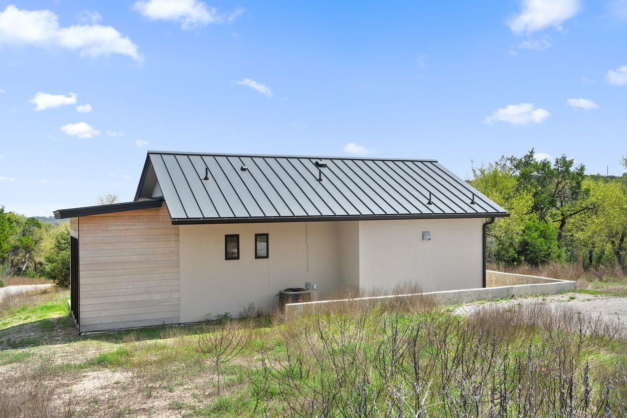 Angled rear view of a detached casita by J. Angelo Design Build in Austin, TX with a minimalist design and natural wood accent