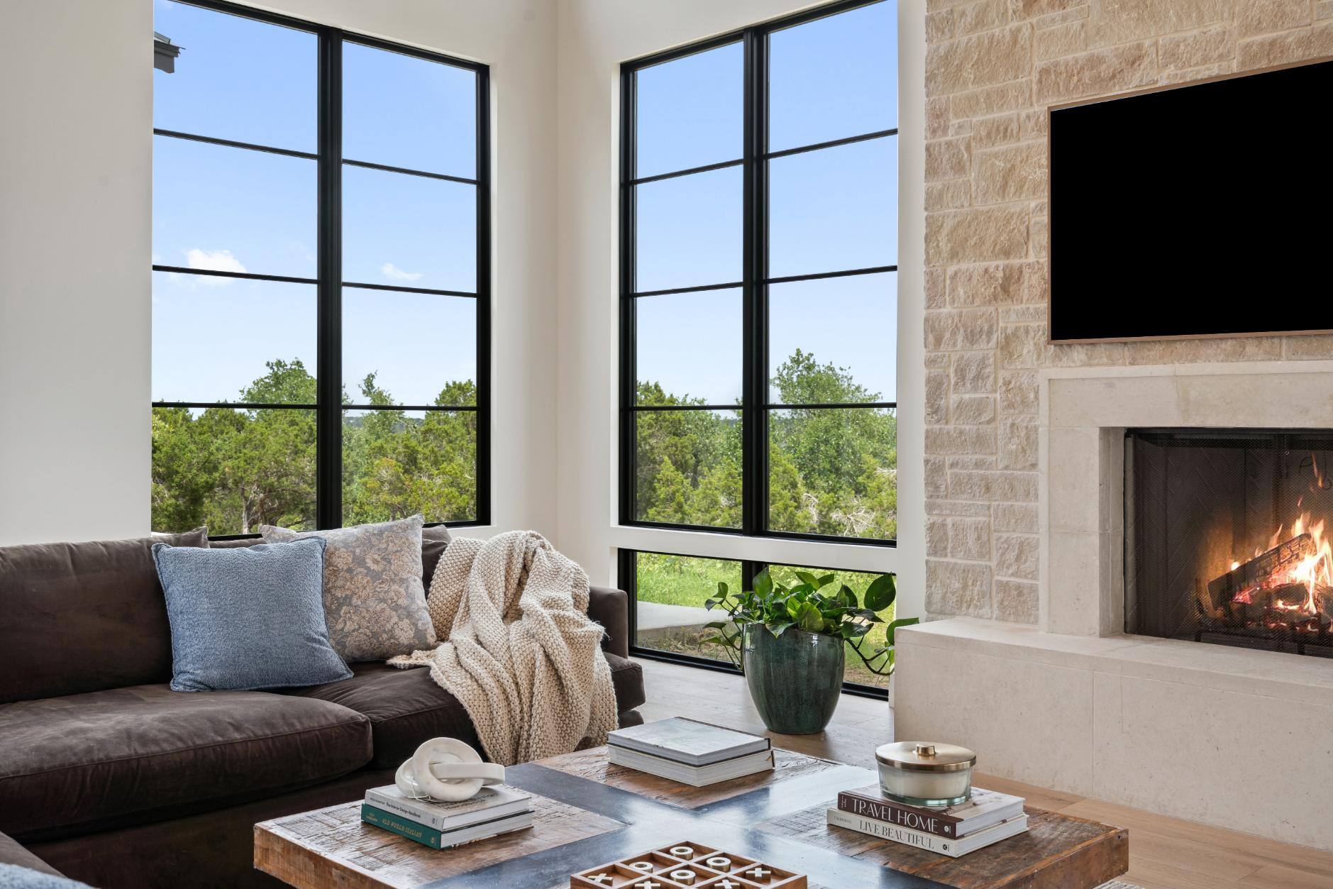 Corner of living room with large windows and fireplace in custom home by J. Angelo Design Build in Southwest Austin, TX