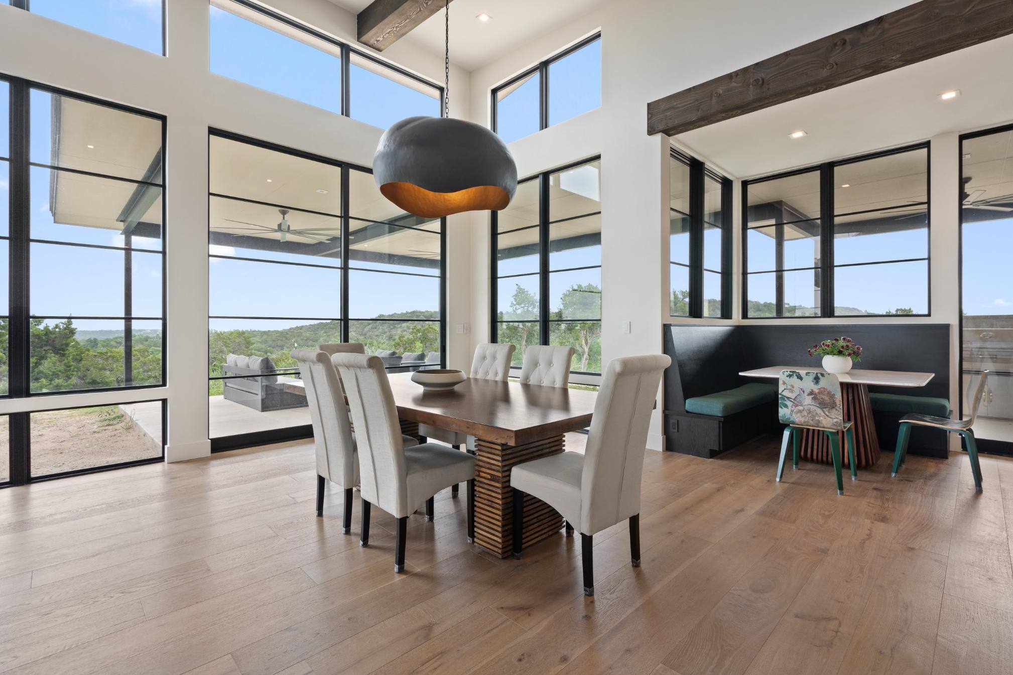 Dining area and breakfast nook featuring large windows in custom home built in Austin, TX by J. Angelo Design Build