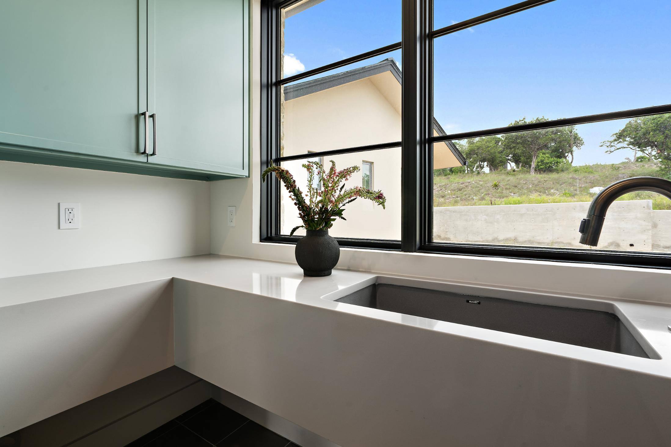 Laundry area with a large sink and modern cabinetry in a custom home by J. Angelo Design Build in Southwest Austin, TX