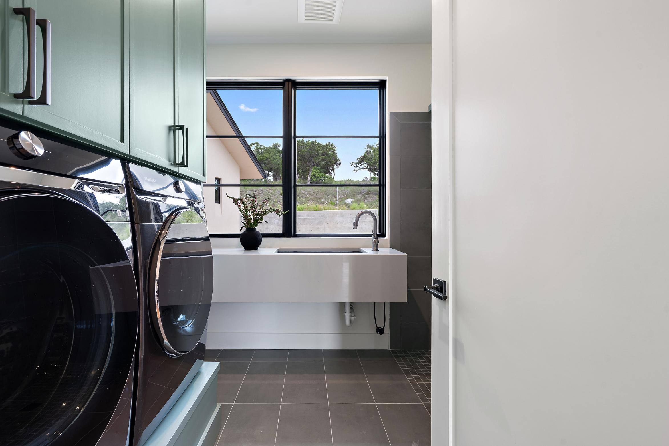 Laundry room in a custom home by J. Angelo Design Build in Southwest Austin, TX, featuring modern appliances and large windows