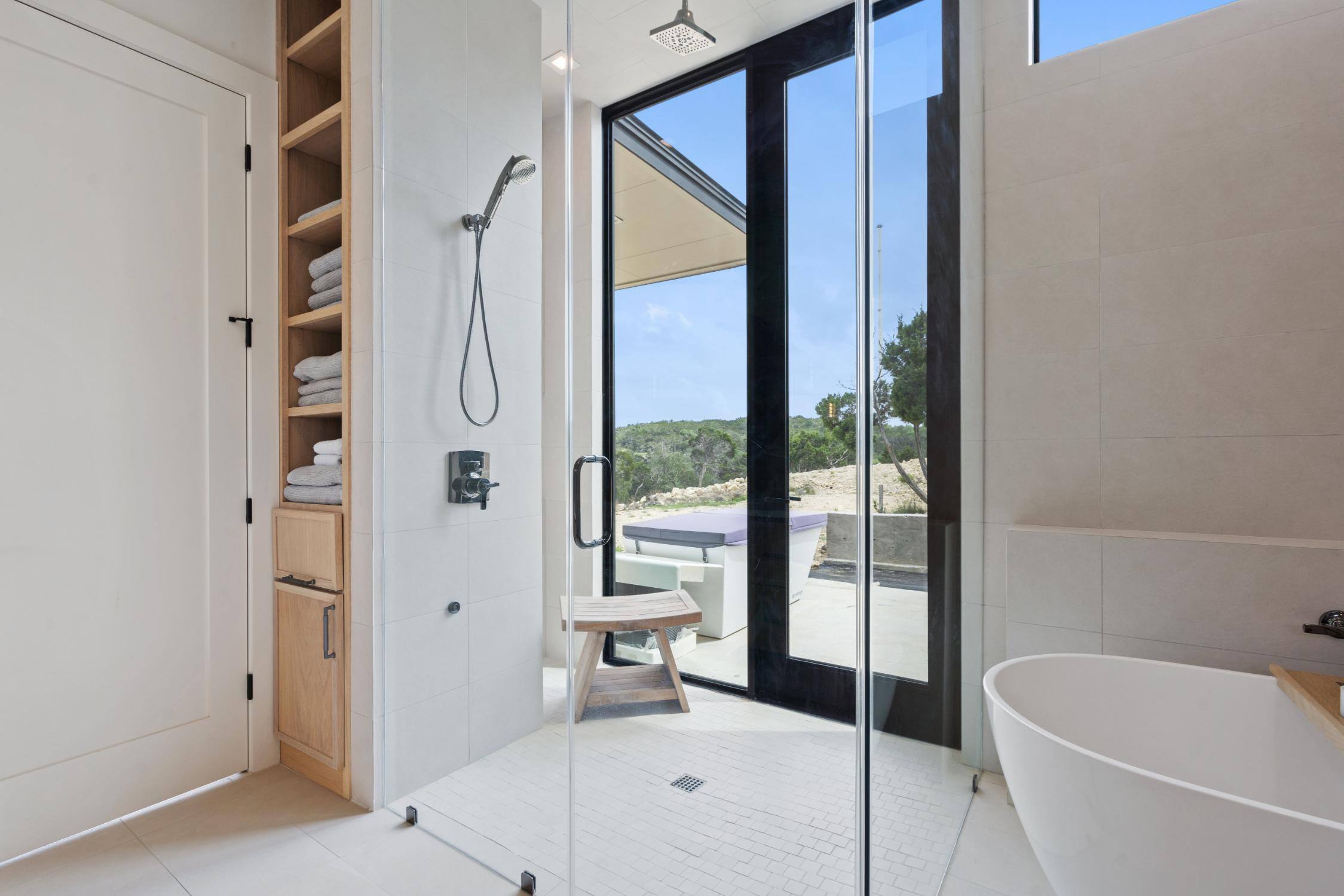 Master bathroom walk-in shower with door to backyard custom home by J. Angelo Design Build in Southwest Austin, TX