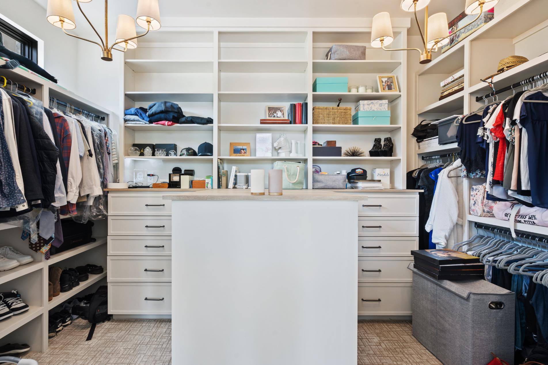 Master bedroom walk-in closet with open shelving storage, drawers, and island custom home by J. Angelo Design Build in Southwest Austin, TX