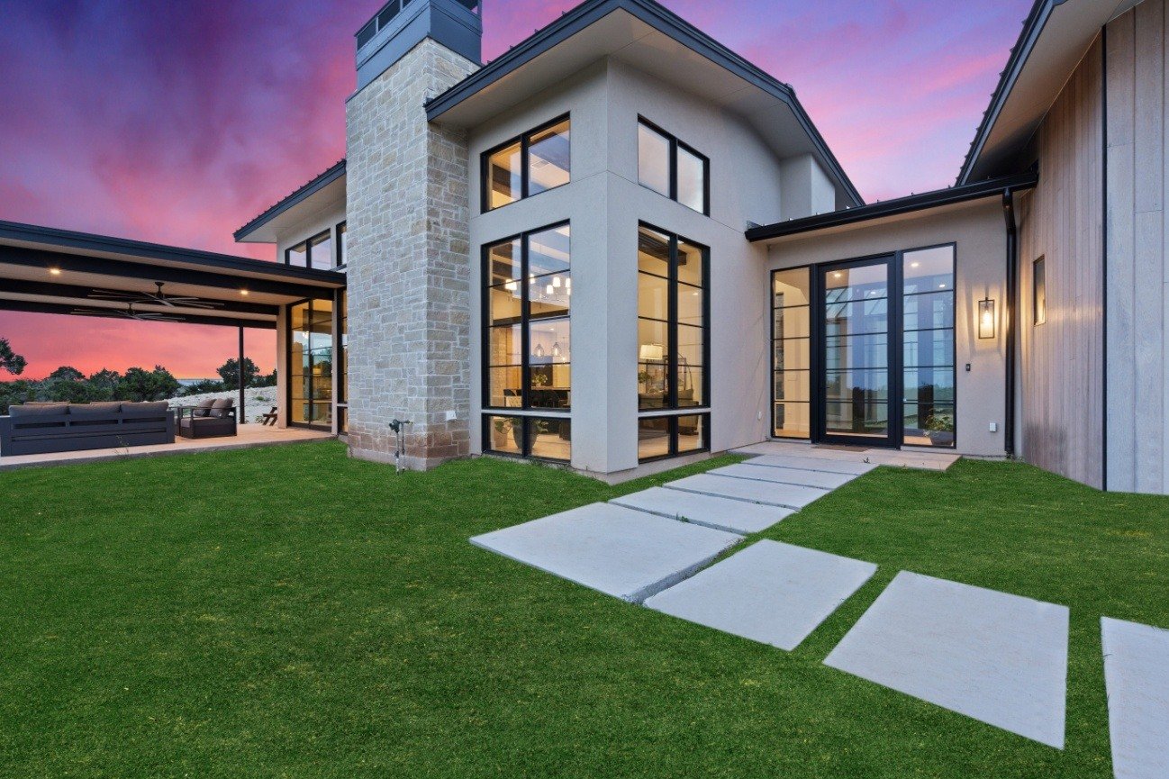 Custom home with expansive windows and covered patio space, designed by J. Angelo Design Build in Southwest Austin, TX