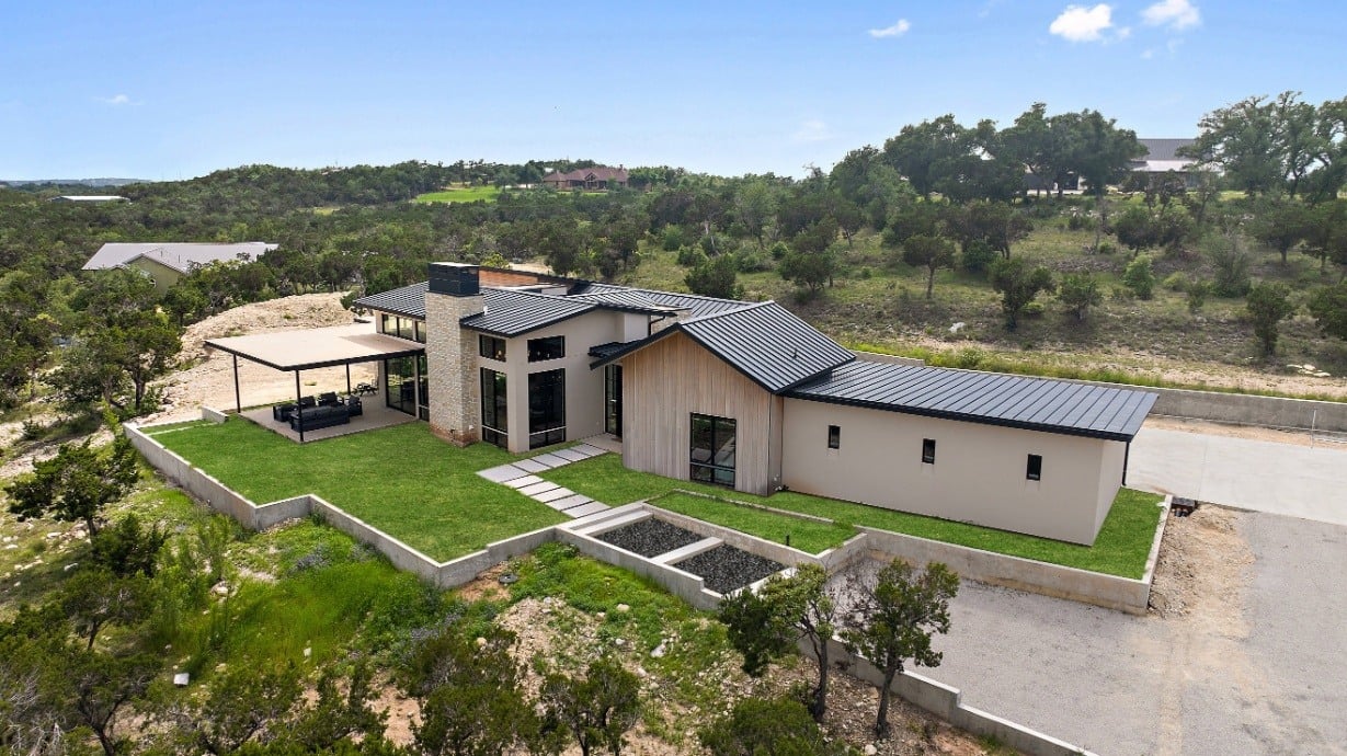 Side view of a modern custom home by J. Angelo Design Build in Southwest Austin, TX, with landscaping and open space