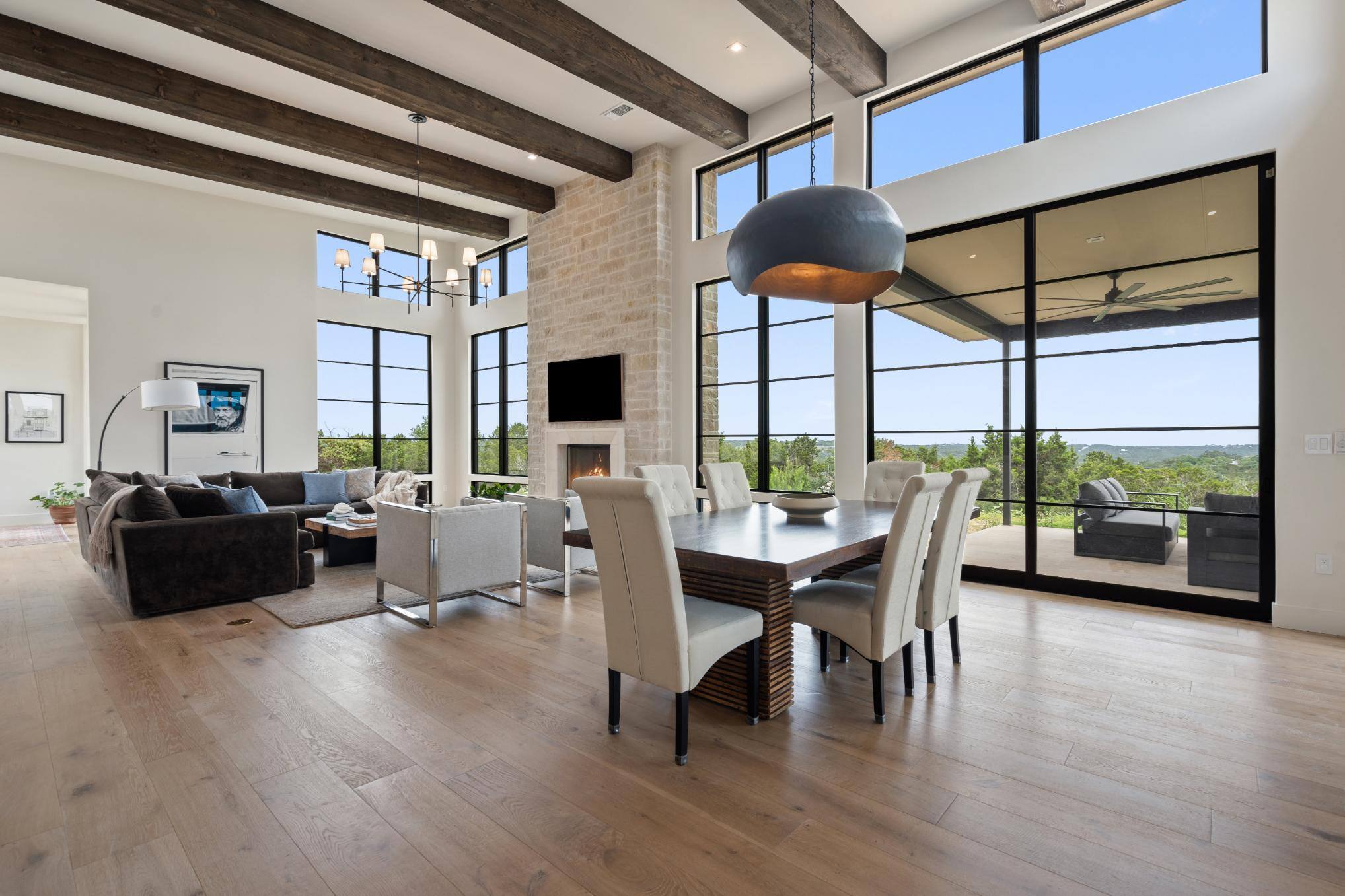 Open-concept living and dining area with high ceilings and fireplace in a custom home by J. Angelo Design Build in Southwest Austin, TX.