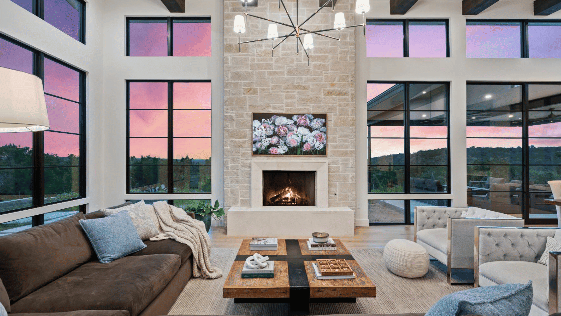 modern open living room with fireplace stone and full windows by J. Angelo Design Build