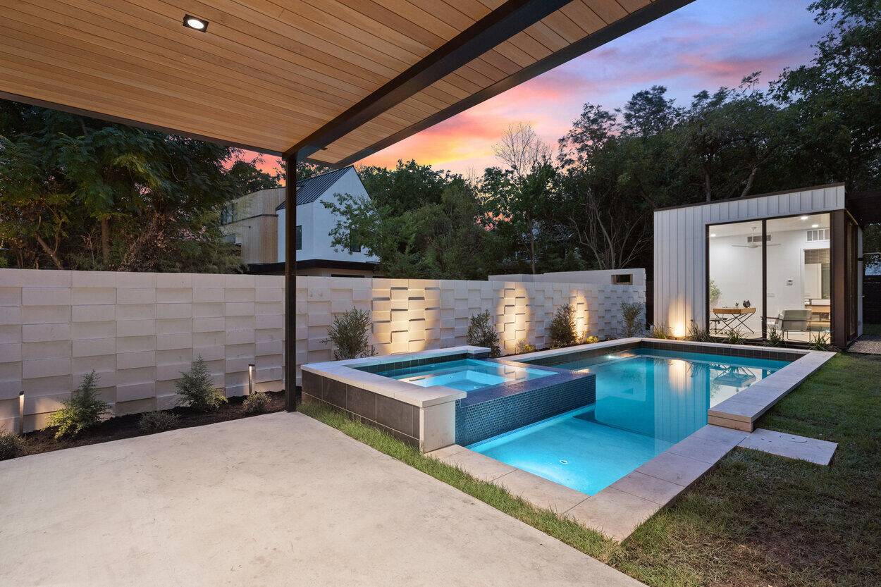 Covered patio and backyard swimming pool of custom home by J. Angelo Design Build in Austin, TX