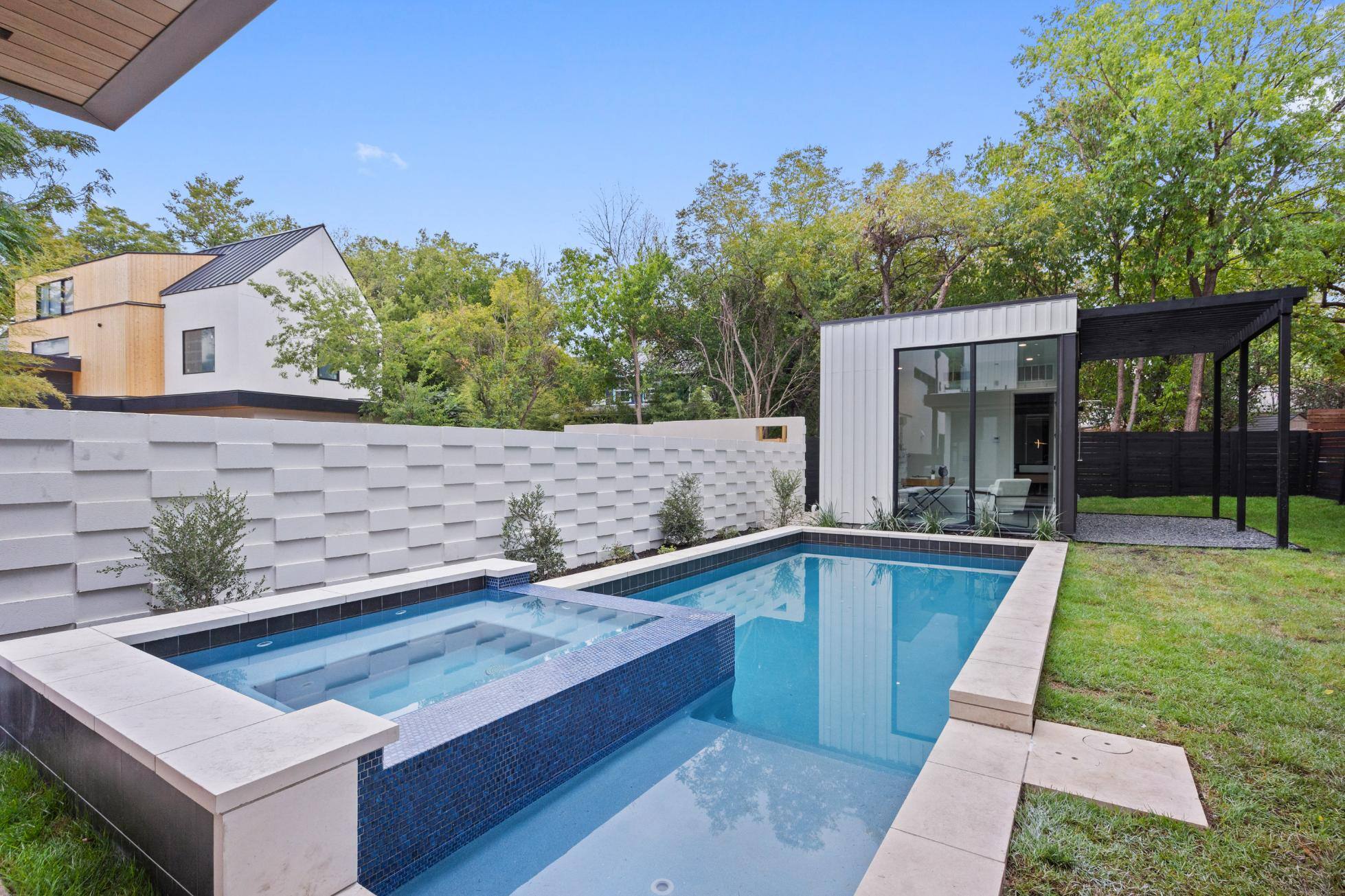 Backyard pool area with view of custom home in Austin, TX by J. Angelo