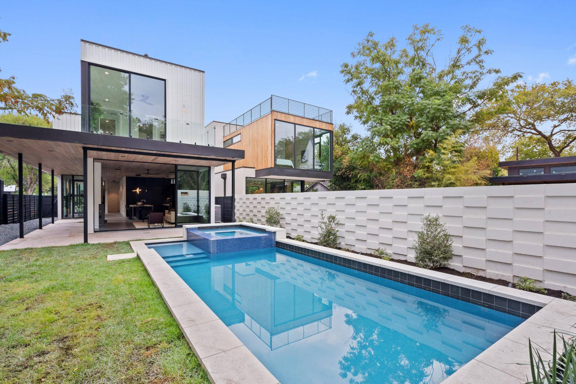 Backyard pool of custom home featuring porch area by J. Angelo Design Build in Austin, TX