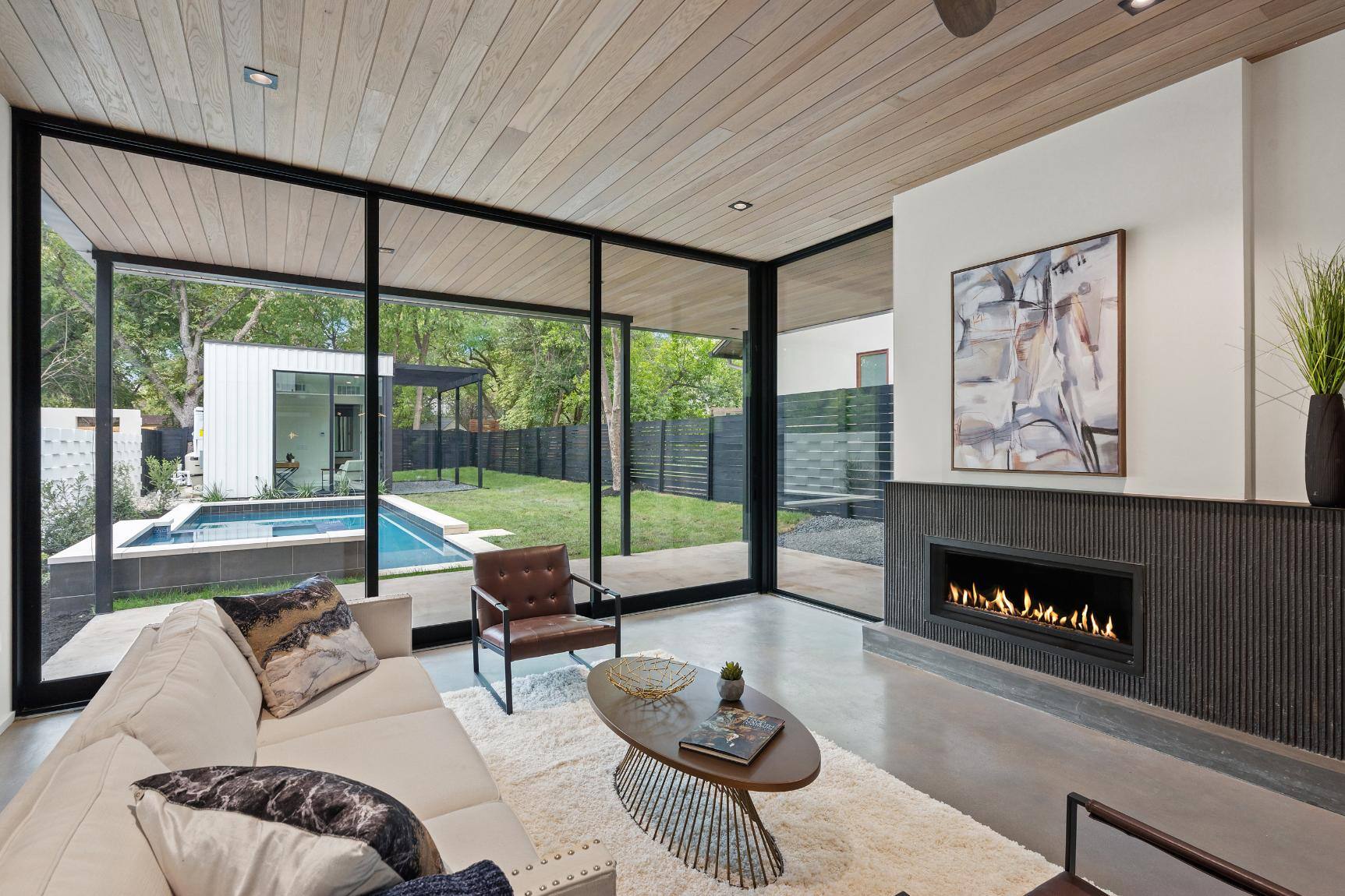 Custom living room featuring build-in fireplace and floor to ceiling windows in custom home by J. Angelo Design Build in Austin, TX